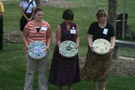 From left to right: Legal Advocate from People Against a Violent Environment, Ashley Welak, DOJ-Office of Crime Victims Services Sexual Assault Victim Services Grant Specialist, Karen Moore, and DOJ-Office of Crime Victim Services Victims of Crime Act Grant Specialist, Amy Byrnes, presenting commemorative stones at the National Day of Remembrance for Murder Victims 2010 Ceremony in Watertown, Wisconsin. Each stone is inscribed with a word from the 2010 theme â€˜Remember. Remind. Respect.â€™
